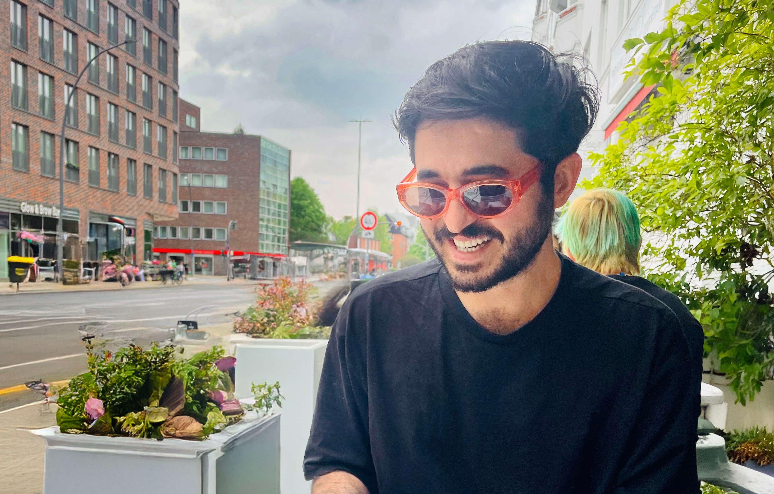 Portrait photo of Soner Kaya sitting and working with computer in a cafe in Hamburg, Barmbek
